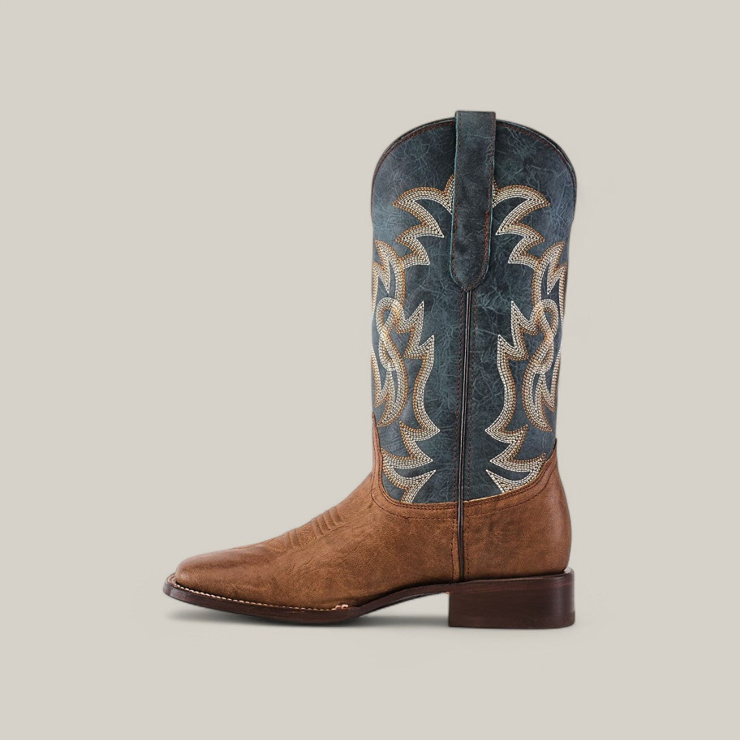 The Sierra Cinnamon - Square Toe boot presents Western style with a brown leather foot and tall blue shaft, detailed with intricate white and brown stitching. Crafted from premium leather, it features a square toe and stacked heel, set against a plain light gray background.