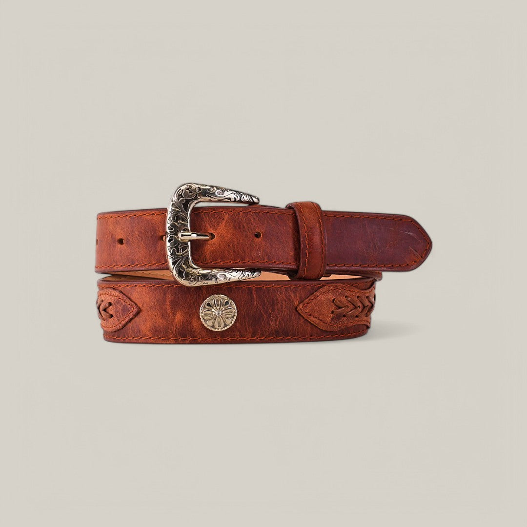The Siberia Cogñac Belt - Roller Buckle is elegantly coiled against a plain background, featuring embossed leather patterns and a decorative silver buckle with a round metal embellishment in a sunburst design, offering timeless elegance with vibrant flair.