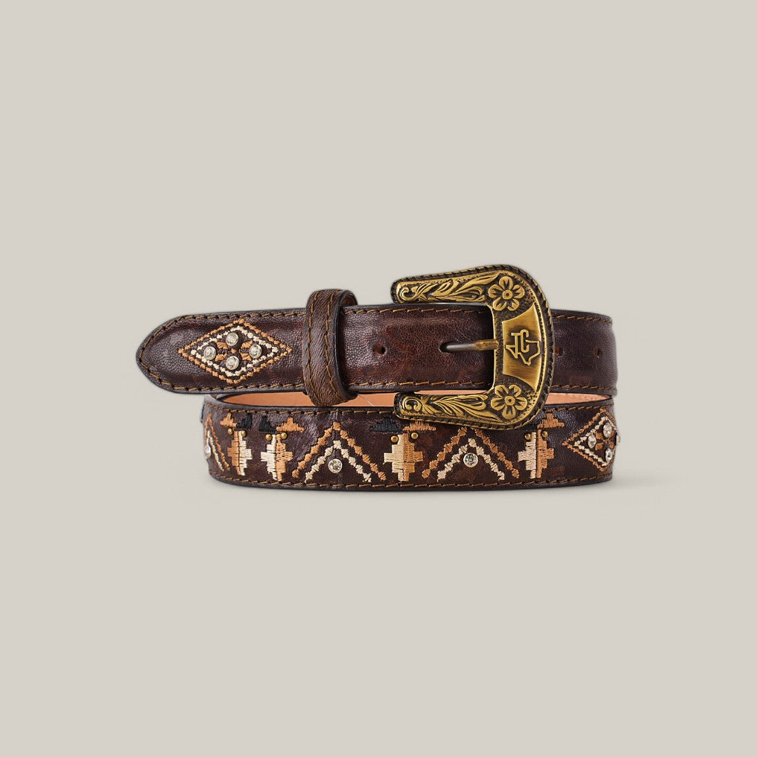 The Oklahoma Aztec Brown Belt - Texas Buckle exudes elegance with its rolled-up brown leather and ornate brass buckle. It features intricate embroidered patterns in beige and brown, with diamond shapes and decorative stitching, making it a perfect fit for any stylish ensemble.