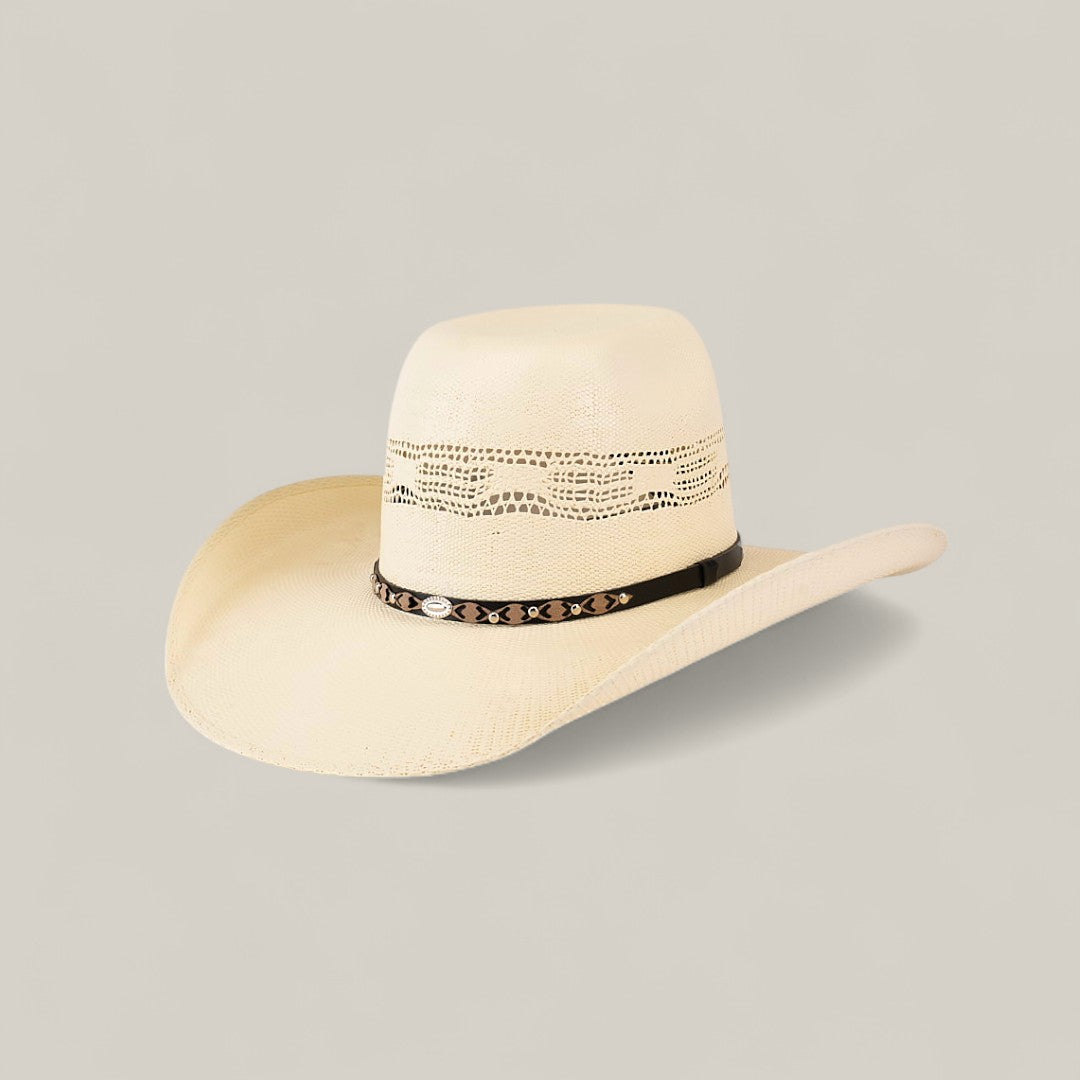 The 50x Brazil Straw Hat features a light beige color, wide brim for sun protection, decorative crown cutouts, and a black hatband with silver accents—ideal for effortless summer style against a plain background.