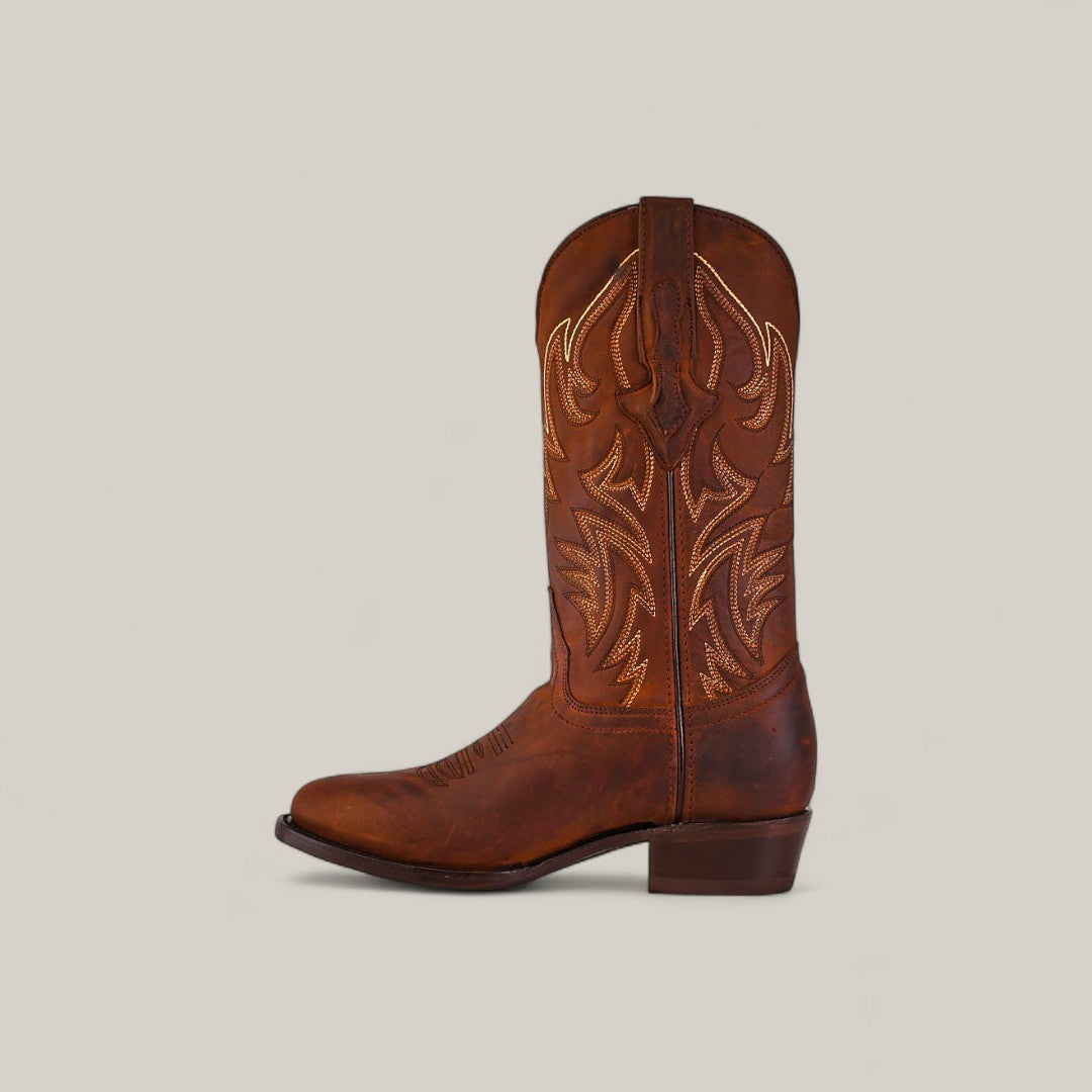 The Dutton - Brick - Roper Toe, a single brown cowhide boot with decorative stitching and a slightly pointed toe, is shown in profile against a plain light background as part of the Last Call collection.