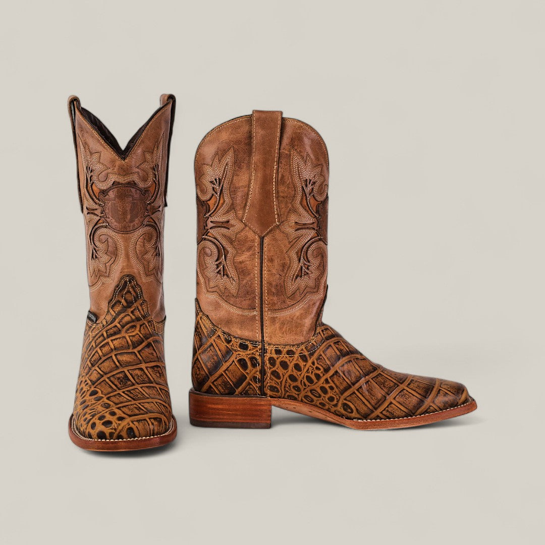 The Jonh - Orix - Square Toe boots feature premium brown leather with intricate shaft stitching and a crocodile-patterned lower section. One boot stands upright, the other lies on its side against a plain light background.