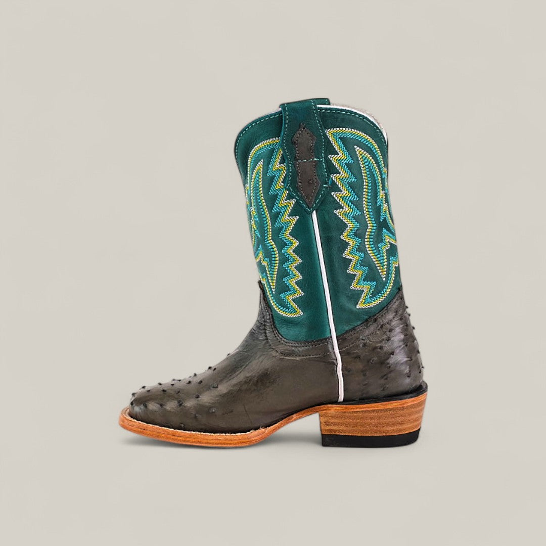 The Exotic Full Quilt Ostrich Gray - Square Toe Kids Boots feature a dark gray ostrich leather foot with a teal shaft, yellow and green stitching, brown wooden heel, and light brown sole, showcased on a light background.
