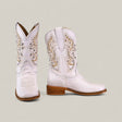 The Amara White - Square Toe - Kids Boots feature light pink leather, intricate tan and white stitching, decorative cutouts, and medium wooden heels for stylish comfort, displayed against a plain beige background.