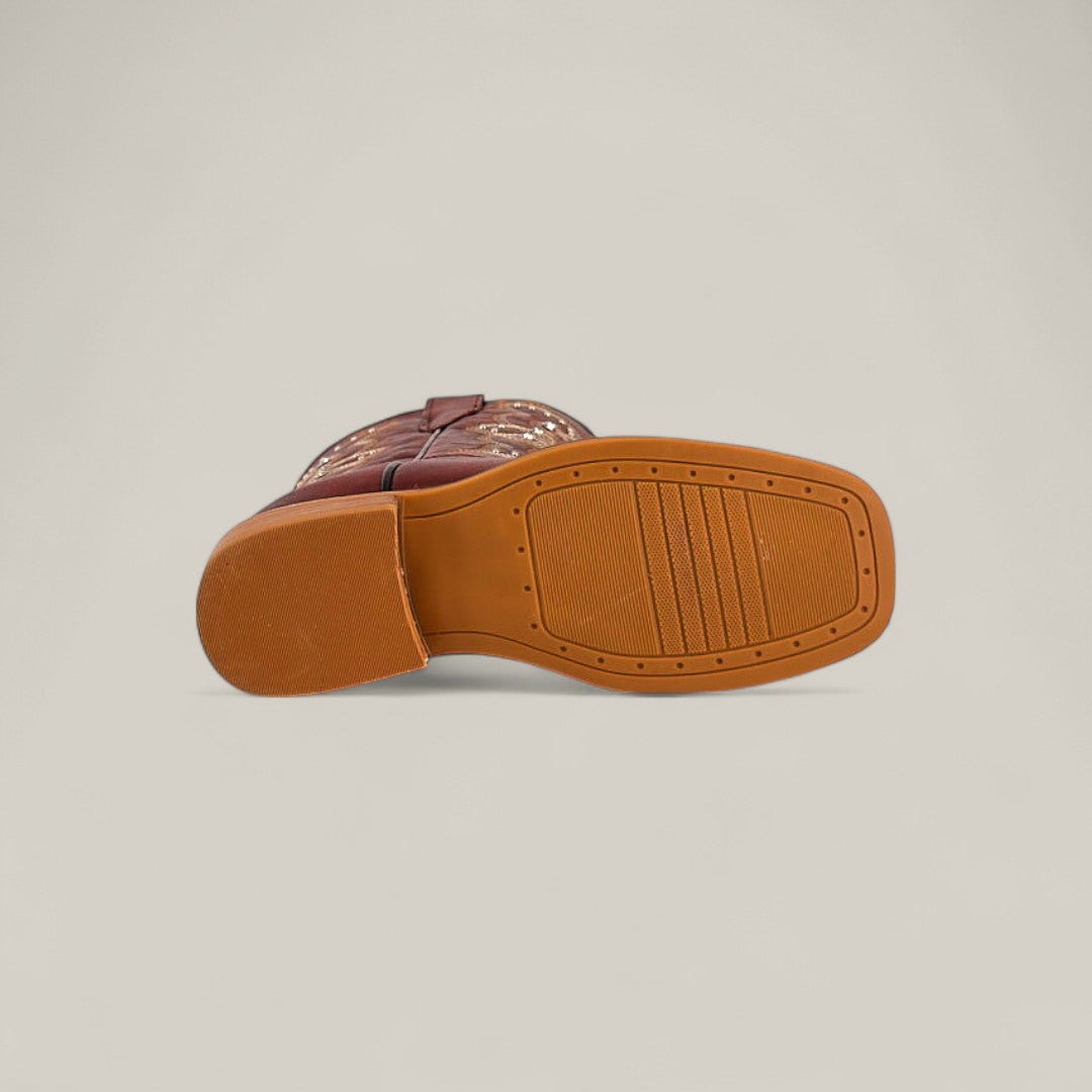 The Blake Cognac - Square Toe - Kids Boots is pictured from the bottom, revealing its tan rubber sole and tread pattern. The boot’s rich brown leather and square toe showcase its classic cowboy style against a light background.