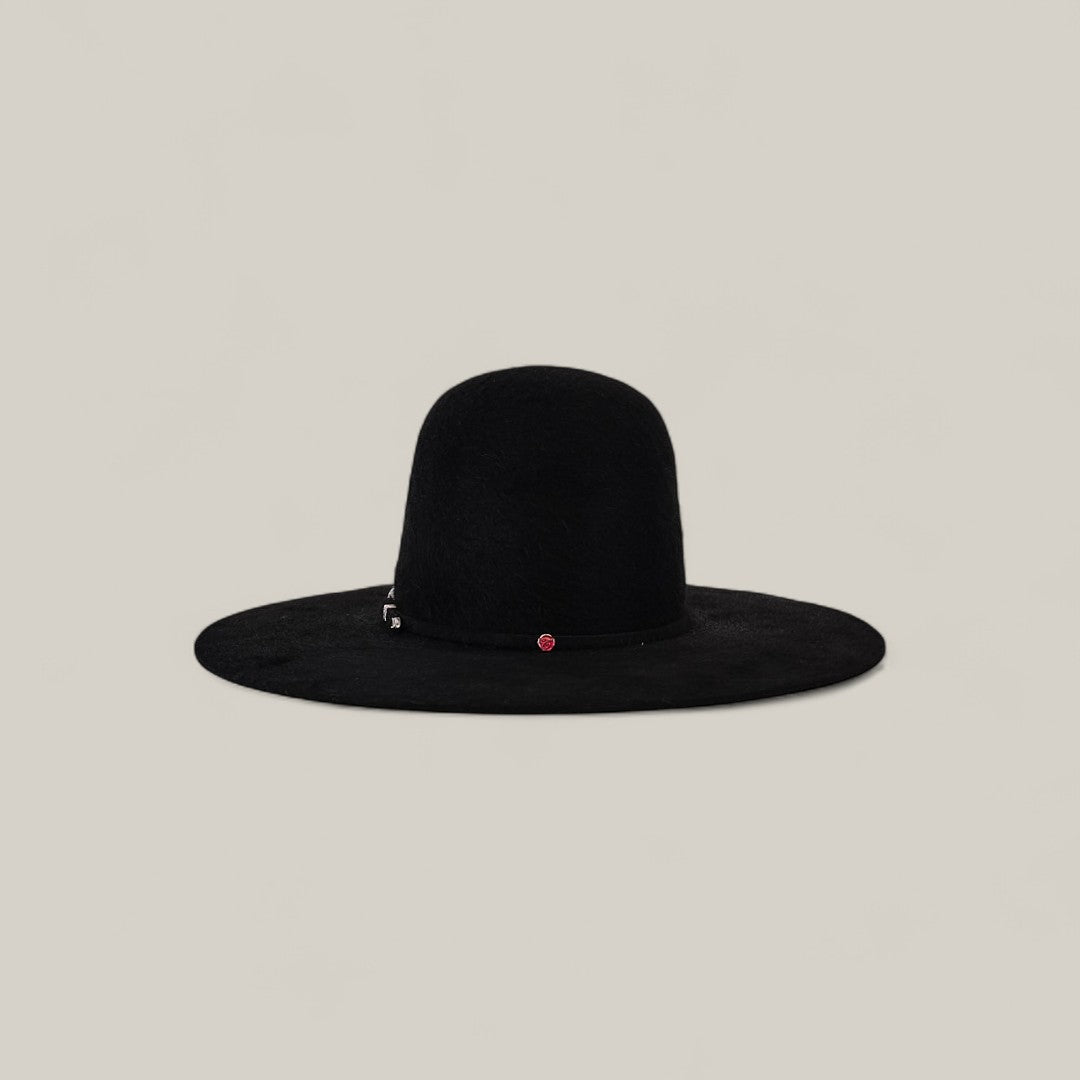 The 10X Grizzly - Tacchino is a wide-brimmed black felt hat with a rounded open crown and a small red accent on the band, shown against a simple beige background.