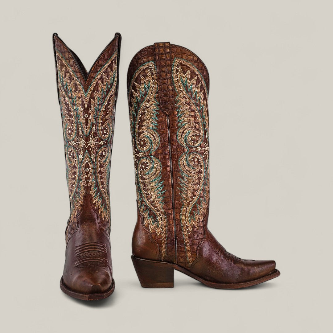 The Rachael Copper - Tall Shaft - Snip Toe boots for women feature brown leather with turquoise, cream, and gold embroidery, a tall shaft, pointed toes, and angled heels, shown against a plain light background.
