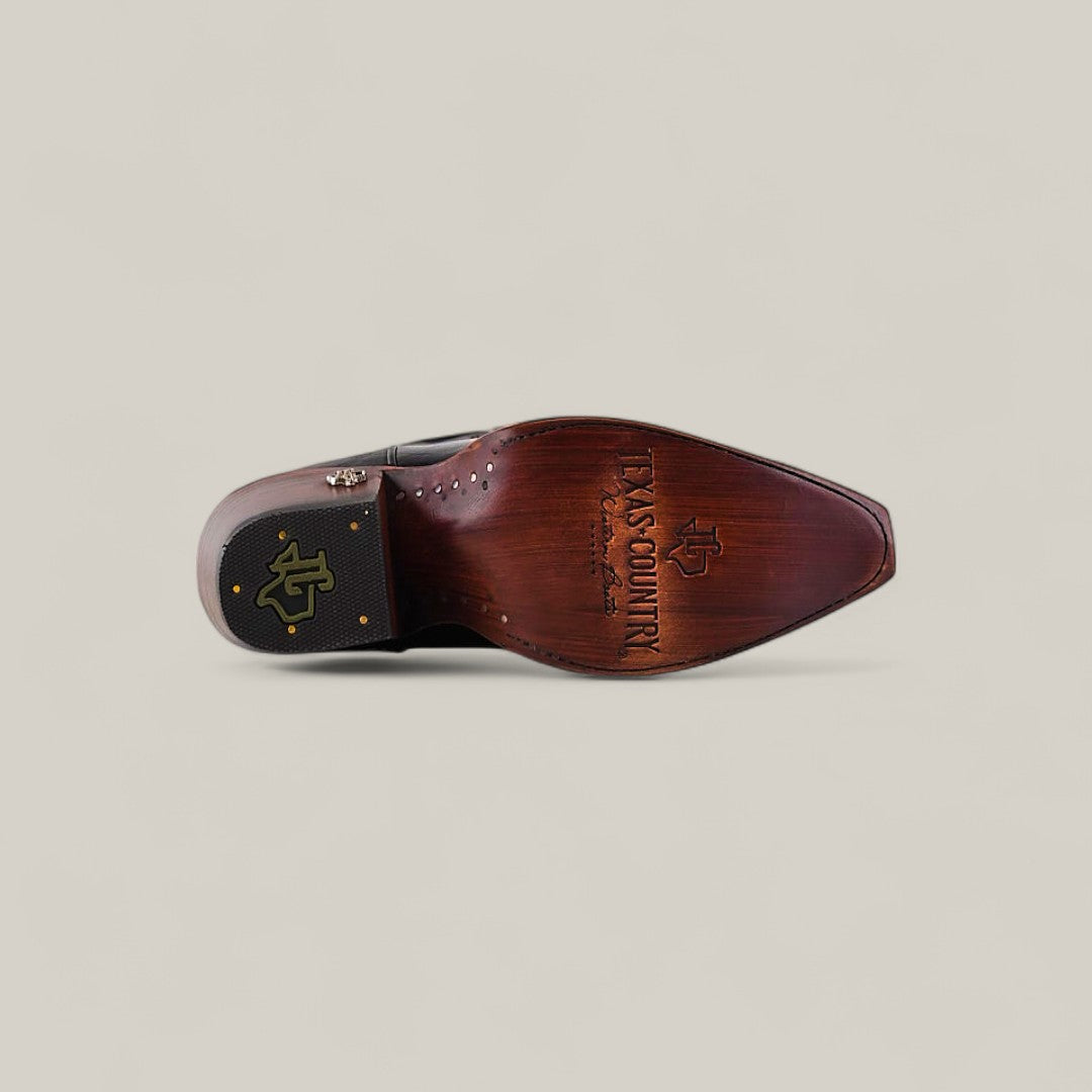 A single Kellie Clayton Black Leather Sole - Tall Shaft - Snip Toe boot is shown from the sole, featuring a brown wooden finish with Texas Country branding and a gold logo near the heel on a neutral background.