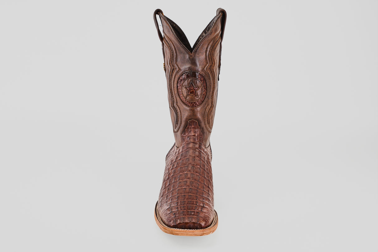The Exotic Caiman Horn Back - Brown - Square Toe boot features a crocodile pattern, decorative stitching, and a circular star emblem, displayed upright against a plain white background.