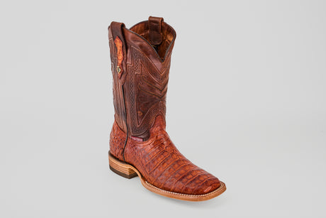 The Exotic Caiman Belly - Brandy - Square Toe boot features a rich brown hue, textured crocodile-like pattern, and decorative stitching, highlighting its luxurious exotic leather against a plain light gray background.
