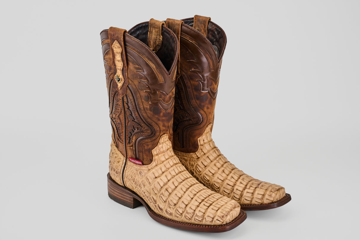 Handcrafted Exotic Caiman Hornback - Orix - Rodeo Toe cowboy boots in tan and brown, featuring a reptile-textured foot and intricate shaft stitching, are displayed on a light gray background.