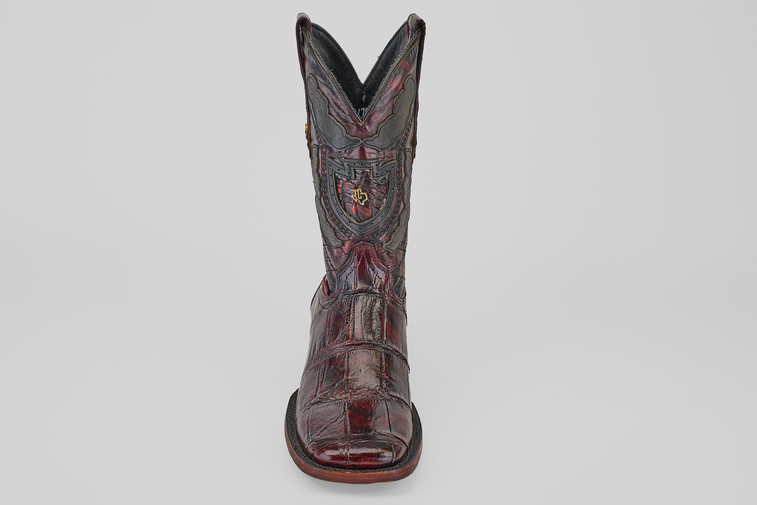 A single Exotic Alligator - BlackCherry- Square Toe cowboy boot with detailed stitching and an embossed crest, shown facing forward on a plain white background.