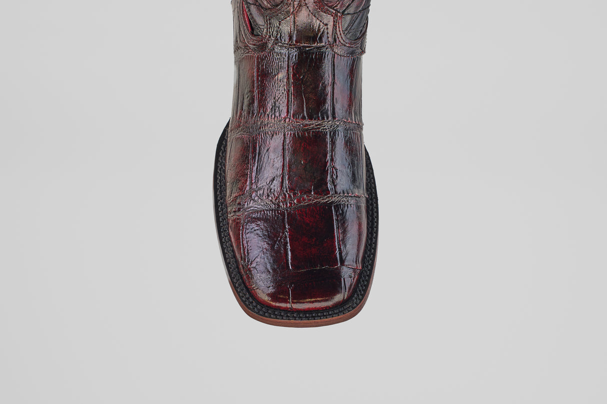 A close-up of the Exotic Alligator - BlackCherry- Square Toe boot shows its shiny, embossed alligator leather and square toe, photographed against a plain white background.