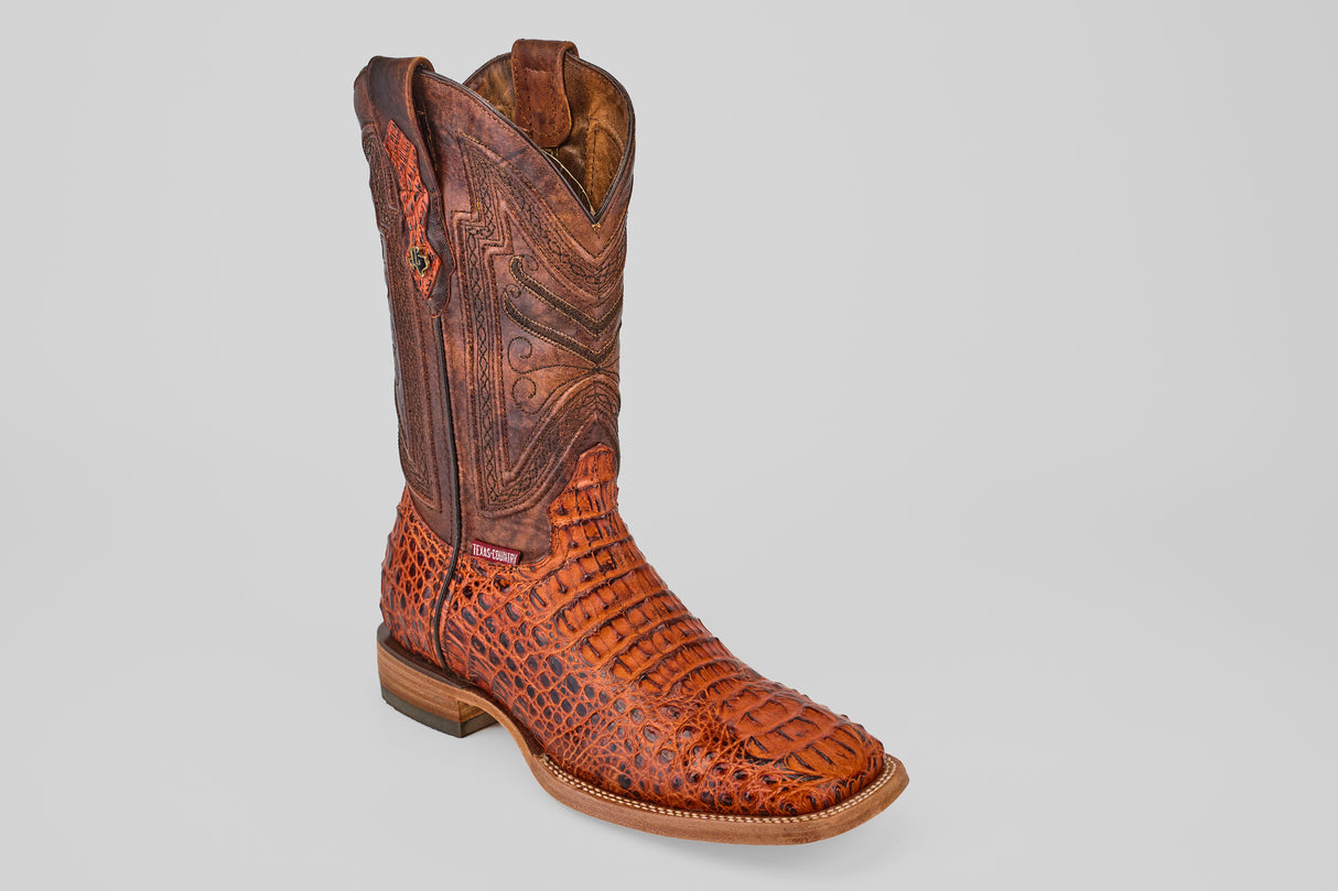 The Exotic Caiman Head - Cogñac boot features rich brown caiman leather with detailed textures, a stylish square toe, low wooden heel, and decorative stitching on the shaft, displayed on a light background.