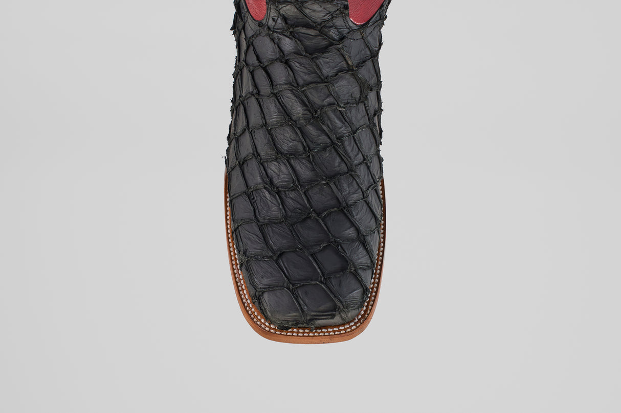 A top view close-up of the Dodge - Matte Black - Square Toe boot showcases its textured Pirarucu leather, square toe design, and brown stitching along the sole—an exemplar of mens luxury boots.