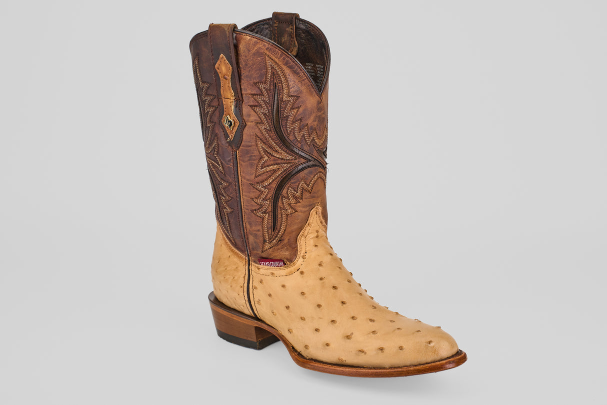 The Exotic Full Quilt Ostrich - Orix - Round Toe cowboy boot features a tall, brown stitched leather upper and a light tan, textured full quill ostrich leather foot, showcased against a plain white background.