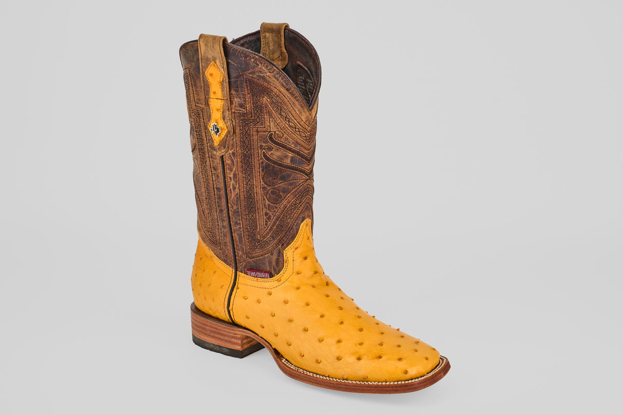 The Exotic Full Quilt Ostrich - Buttercup- Square Toe features a yellow ostrich leather foot and a tall, brown, intricately stitched shaft, displayed on a plain light gray background to highlight handcrafted western style.