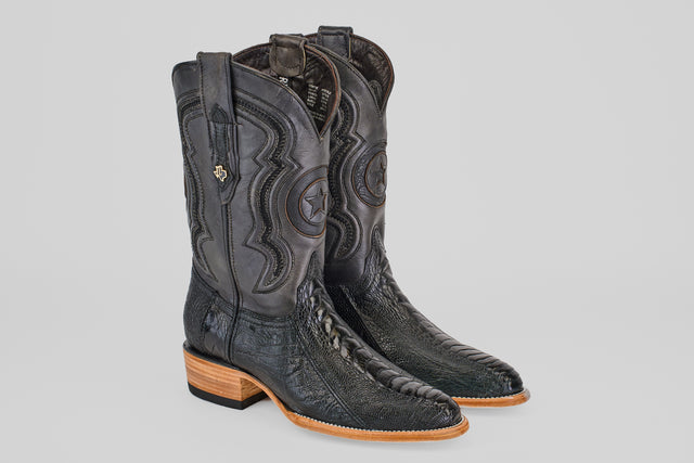 The Austin Leg - Black - Roper Toe boots feature intricate stitching, embossed star designs, decorative pull straps, and a light brown wooden heel and toe, pictured side by side on a light gray background.