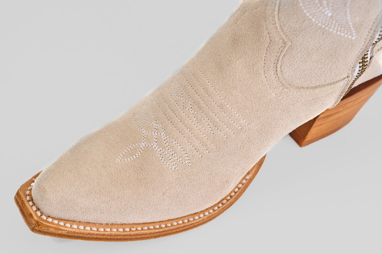 Close-up of Allison Ivory - Tall Shaft - Snip Toe boots featuring ivory leather, white decorative stitching, and a wooden stacked heel—an elegant, modern update on classic women’s western boots set against a light background.
