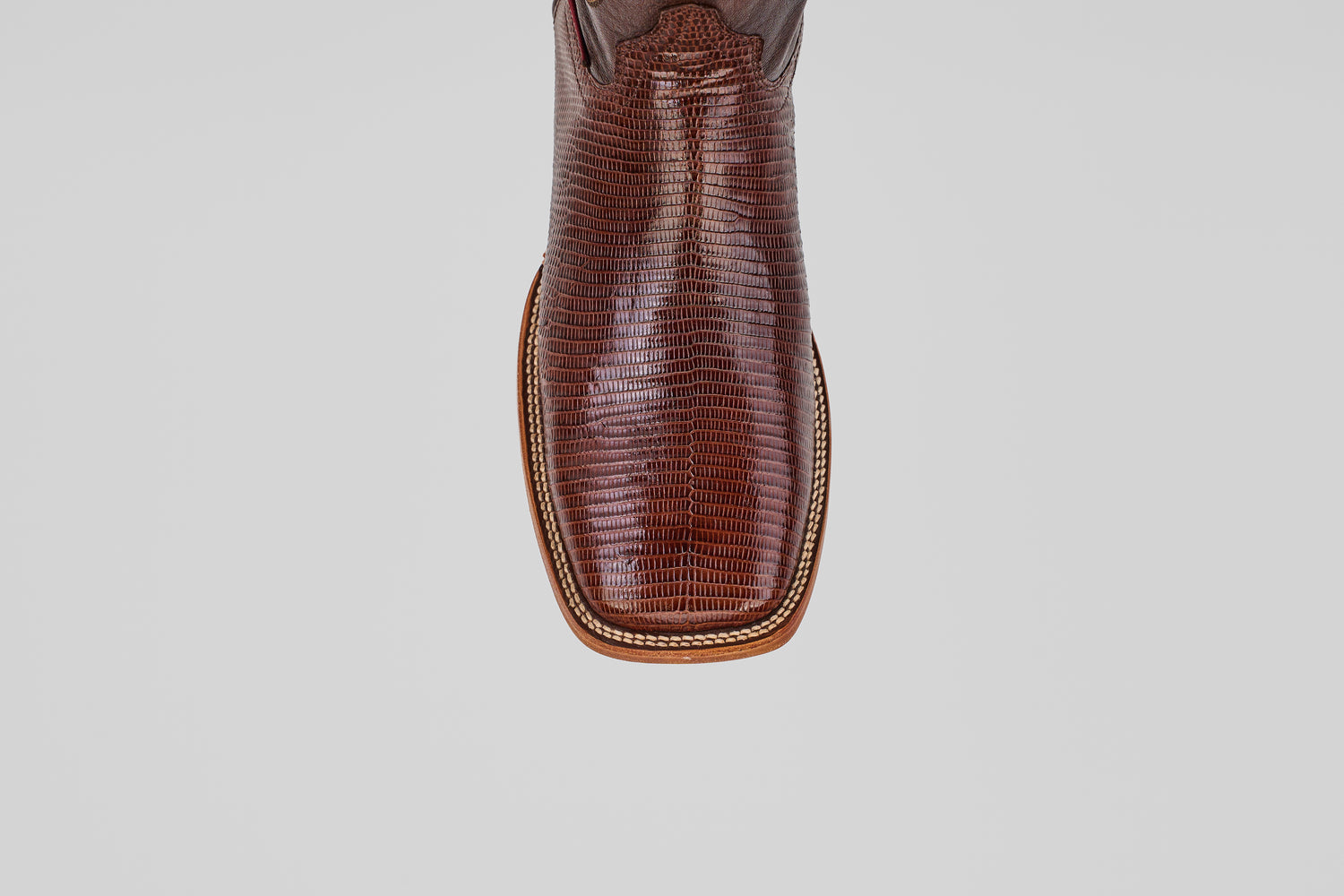 A close-up, top-down view of the toe of the Blaze – Brown – Square Toe boot showcases lizard-textured leather and decorative stitching, highlighting the rugged elegance of this classic western style.