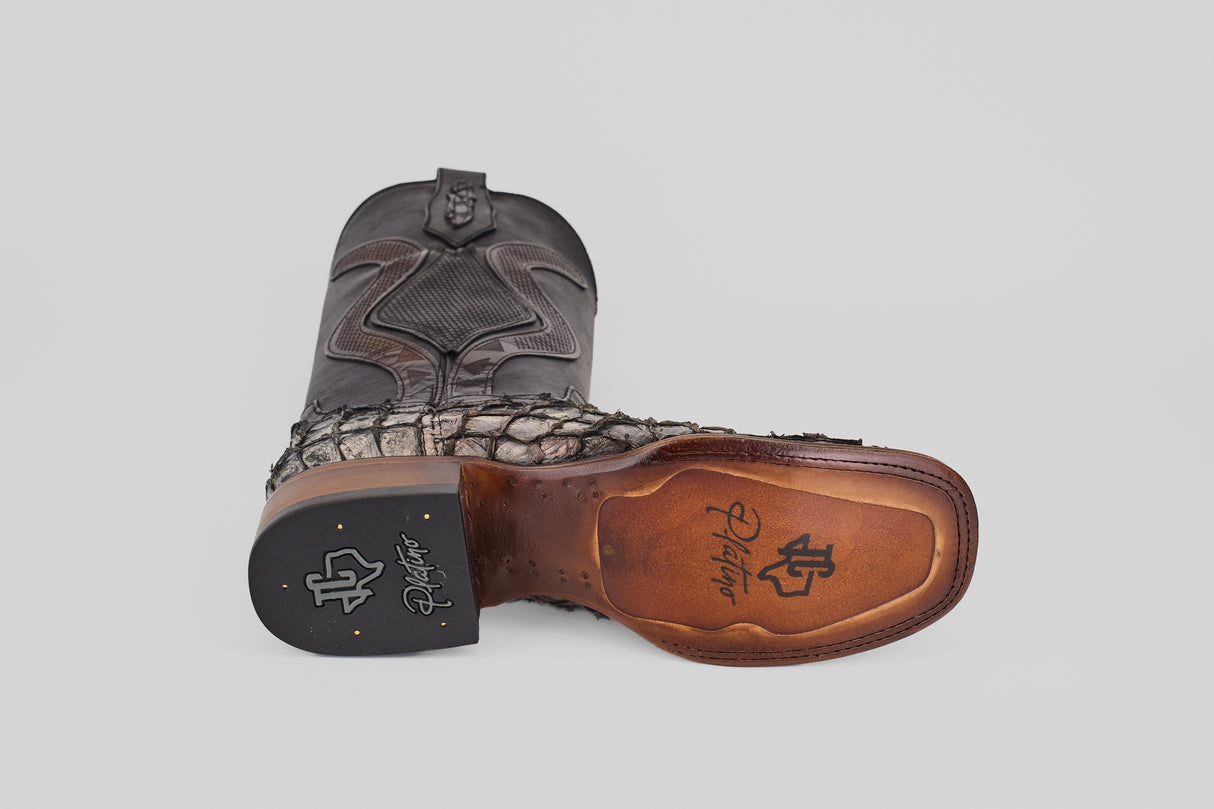 A single Conor Platinum - Newspaper - Square Toe (Diamond) cowboy boot rests on its side, featuring a reptile-like upper and a smooth brown sole with the R. J. Foster logo and initials in black and gold on the heel.
