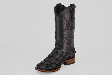 The Conor Platinum - Matte Black - Square Toe (Diamond) boot features a single black design with detailed stitching, an exotic pirarucu-like texture, a brown sole, and is set against a plain light gray background.