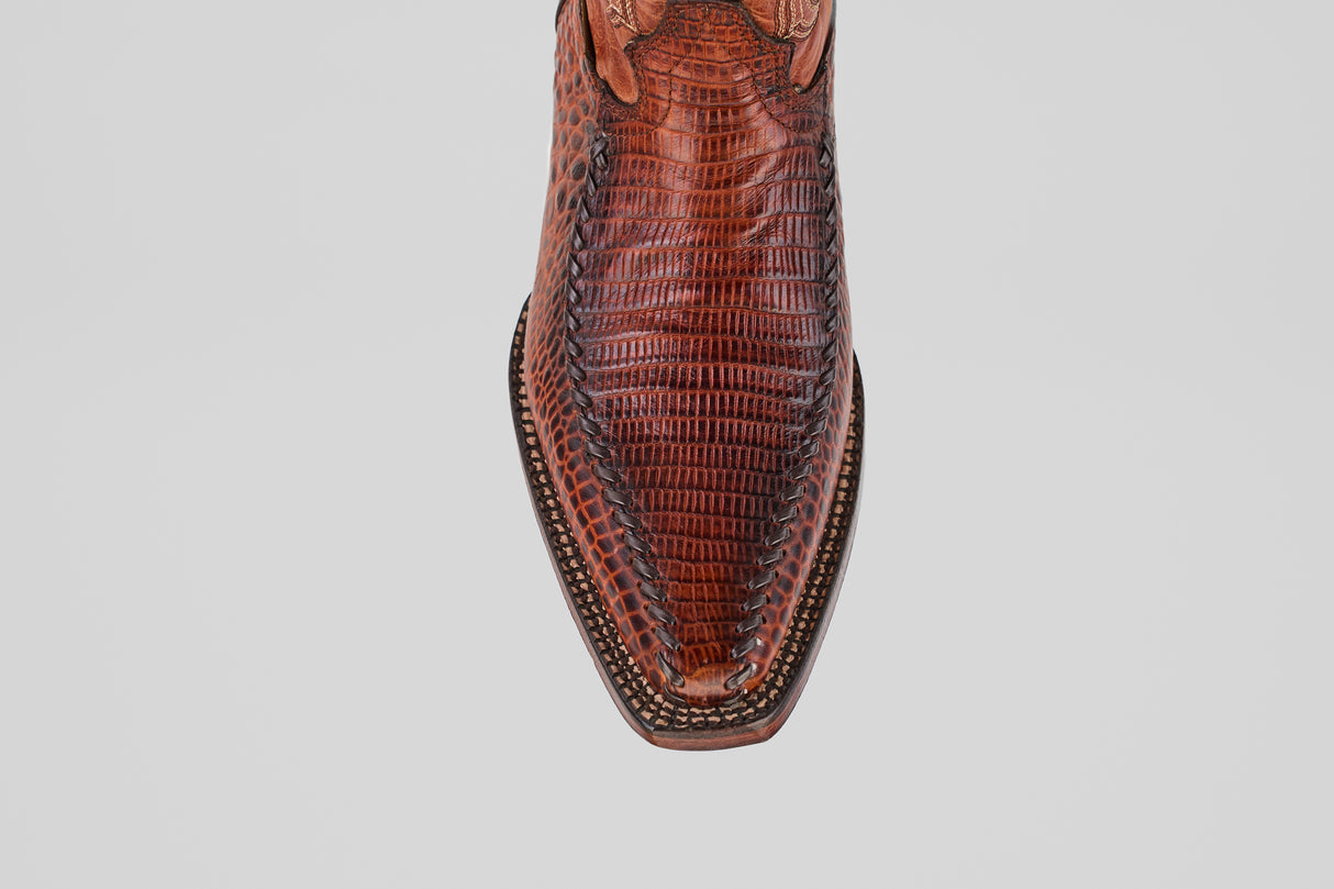 Top view of the Lizard Cogñac - Embossed Leather - Versy Toe (E201) boot with a pointed toe, lizard-embossed texture, and decorative stitching along the sole’s edge on a light gray background.