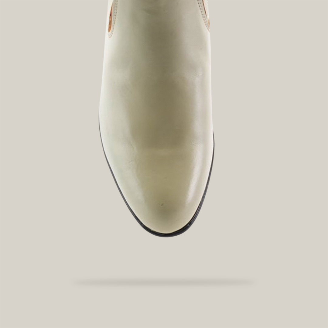 A close-up of the Napa Bone - Round Toe from our western wear collection, featuring light beige leather and subtle stitching on a pointed toe, set against a plain white background.