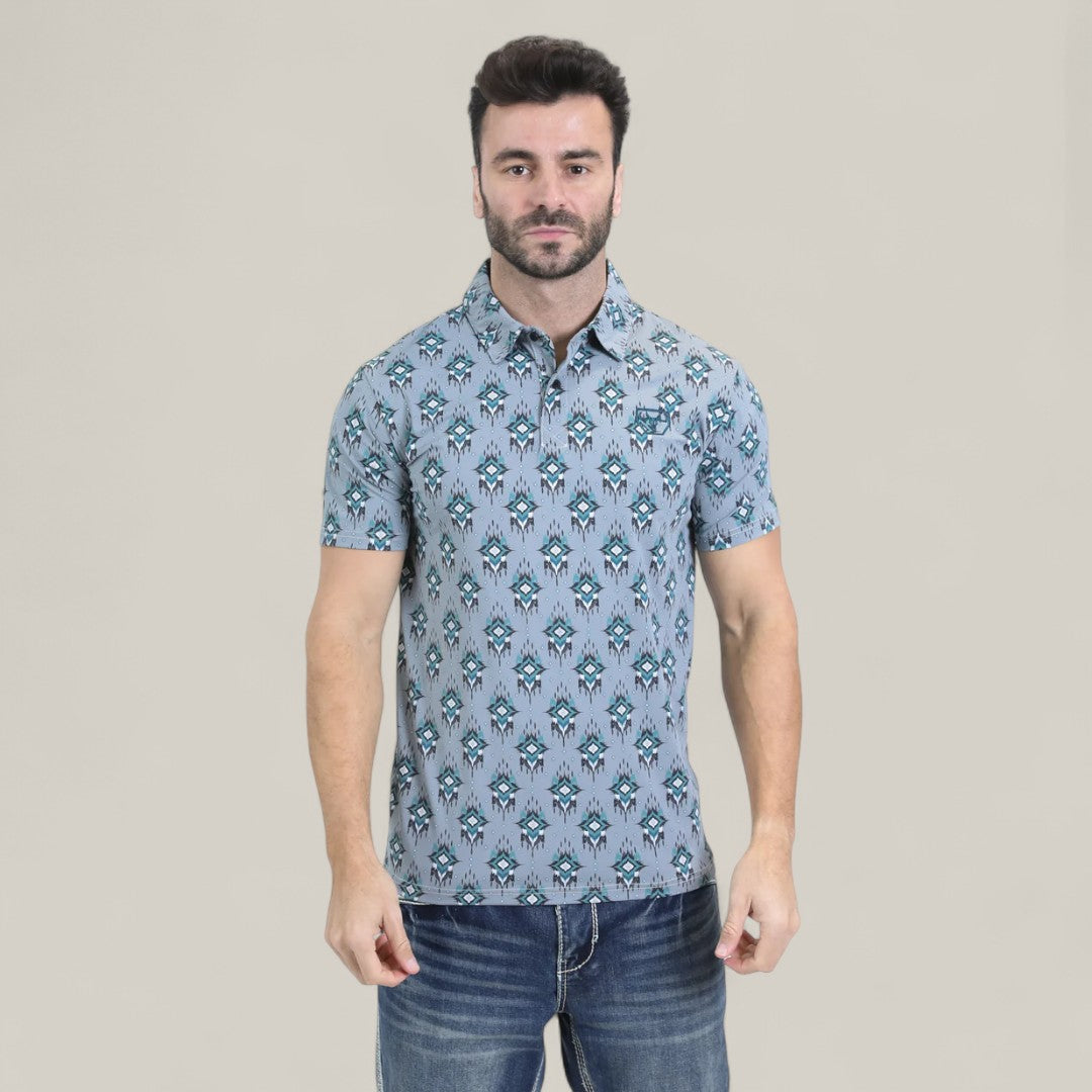 A man with dark hair and a beard wears the Mens Performance Fabric Modern Fit Stretch Aztec Print Blue Polo (PGP10871) and denim jeans, standing against a plain light beige background.