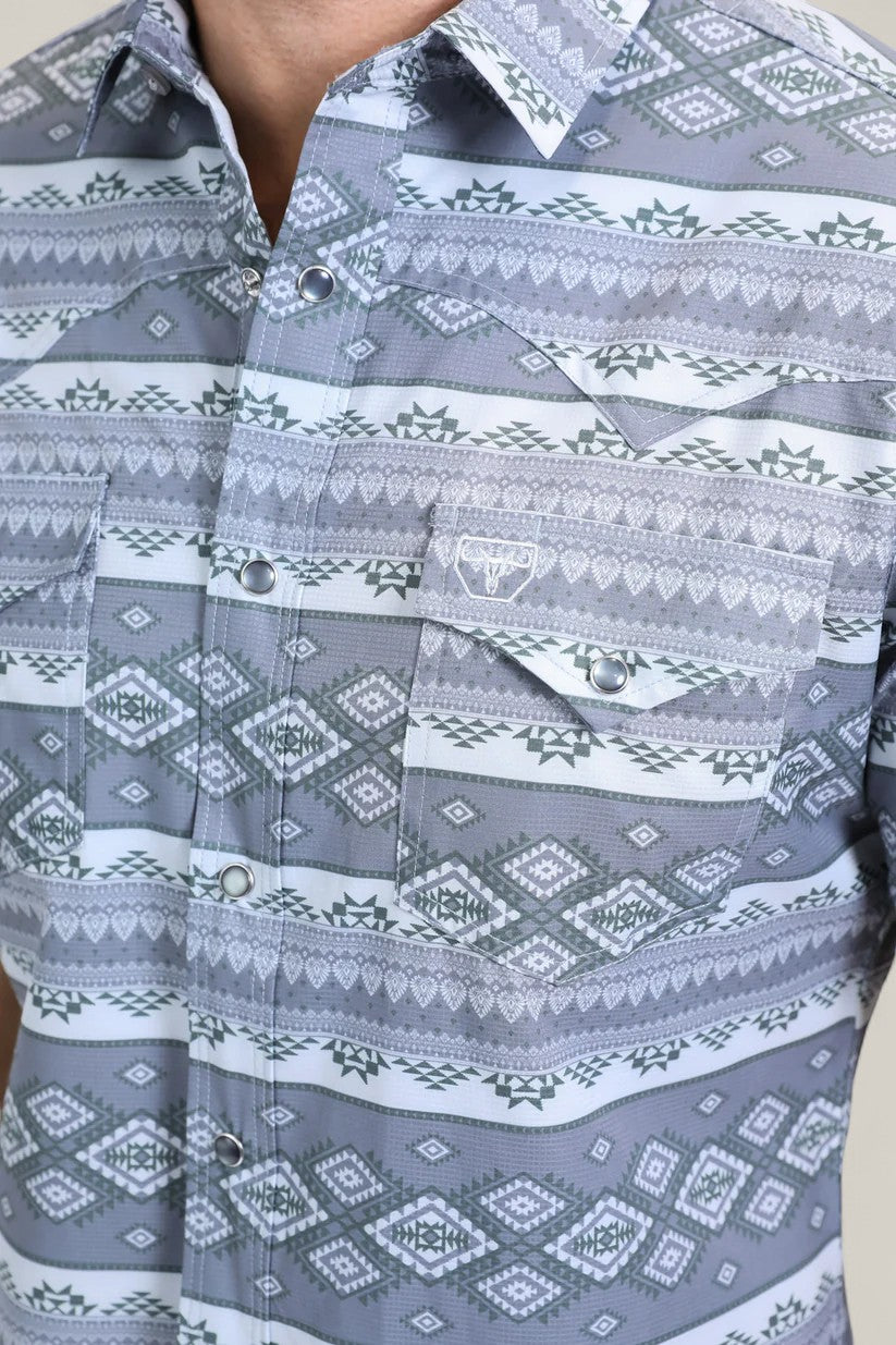 A close-up of the Mens Performance Western Short Sleeve Aztec Print Grey Shirt (PGW10649), featuring a gray and white geometric Aztec print, snap buttons, two chest pockets, and a small embroidered bull head logo.