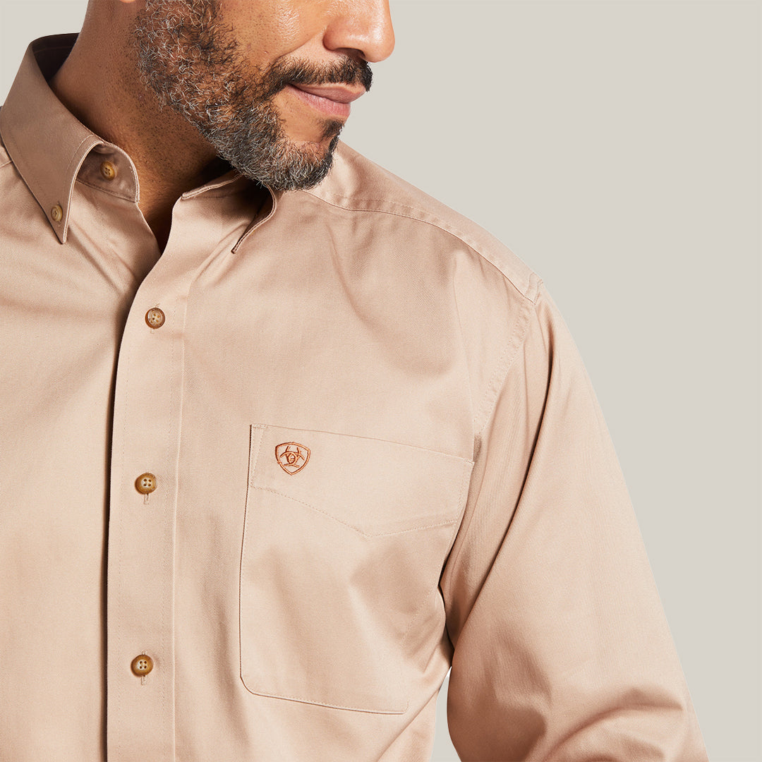 A man models the Kaki Solid Twill Classic Fit Shirt (10000505), featuring elegant embroidery on the chest pocket. The premium cotton twill fabric enhances its refined design and texture, with his face partially visible in profile.
