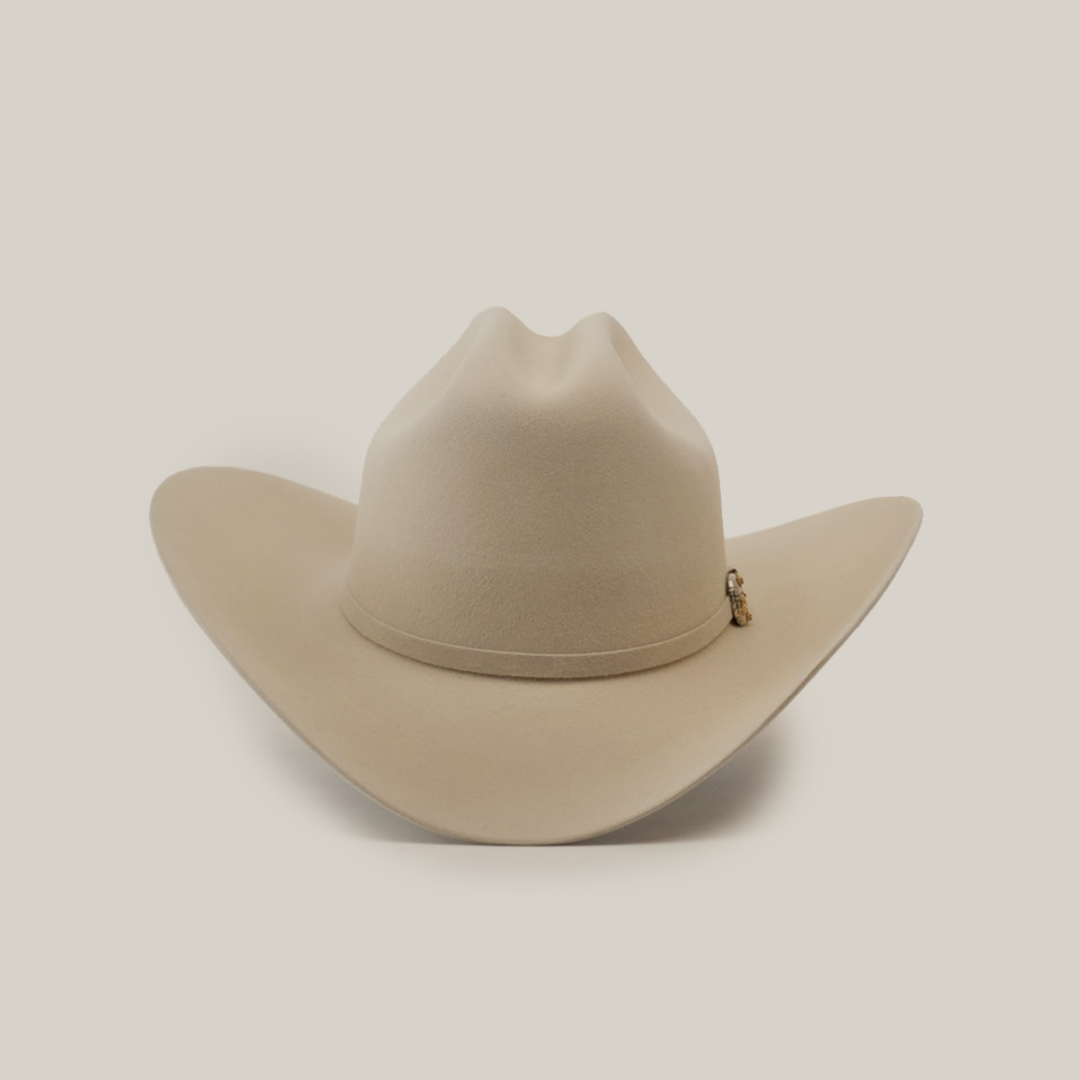 The 1000X Imperial Belly by Larry Mahan is a beige western hat with a wide brim and slightly creased crown, highlighted by a small decorative charm on the band, displayed against a plain white background
