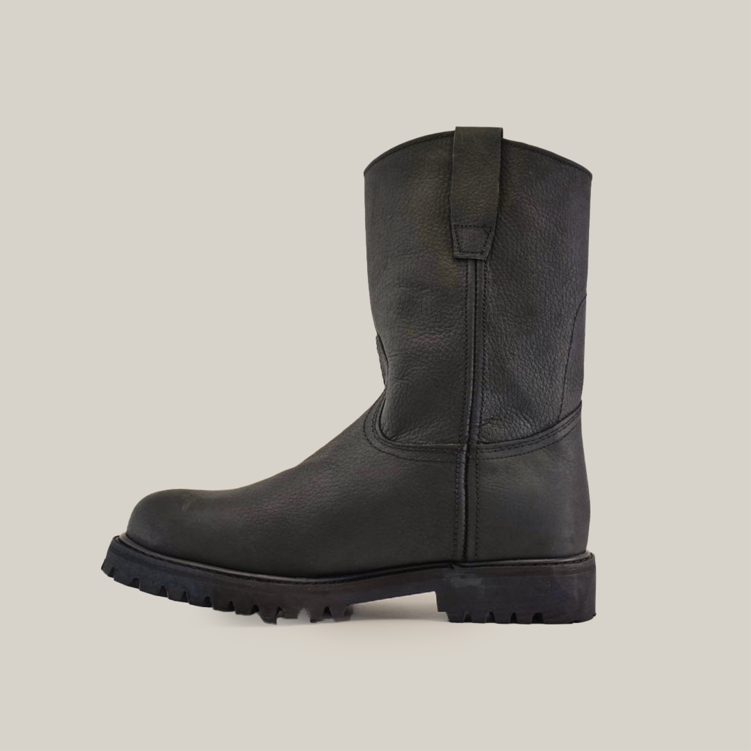 The Black Roper - Tractor Sole - Soft Toe is displayed side-on against a white background, showcasing its mid-calf height. Made from premium cowhide, it features a rugged tractor sole with thick treads and includes a pull tab at the top for easy wearing.