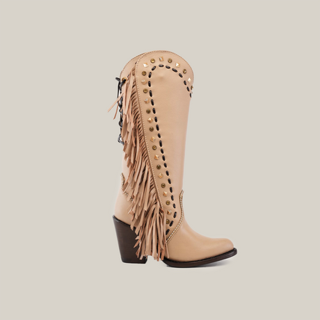 A single Praga Fringe Tall Shaft Cream - J Toe boot from the Platinum Collection, adorned with fringe and gold studs, stands against a white background. This handcrafted boot features a thick, dark heel and decorative gold stud patterns along its upper edge.