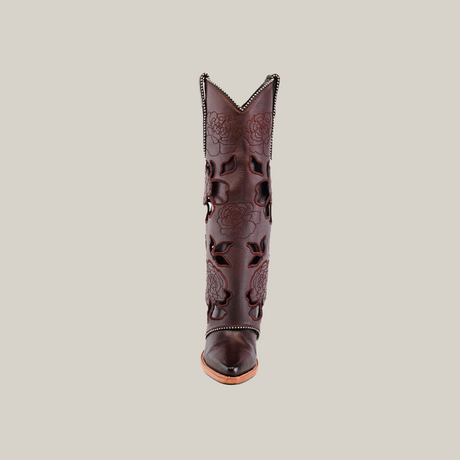 The Roma Flowers Tall Shaft Chocolate boot, part of the exclusive Platinum Collection, is shown in a front view against a white background. It features floral embossed leather details and decorative stitching, with a classic J toe shape for an authentic western look.