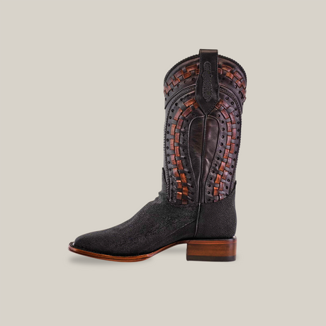 The Exotic Stingray - Herradura in black features a textured shaft with brown and black geometric designs. Handcrafted for durability, it has a wooden heel and a Goodyear welt sole for quality.