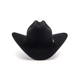 Against a plain white backdrop, the 6X Real Black cowboy hat with a wide brim and pinched crown stands proudly, featuring a small pin on the side that echoes the classic style of a Larry Mahan hat.