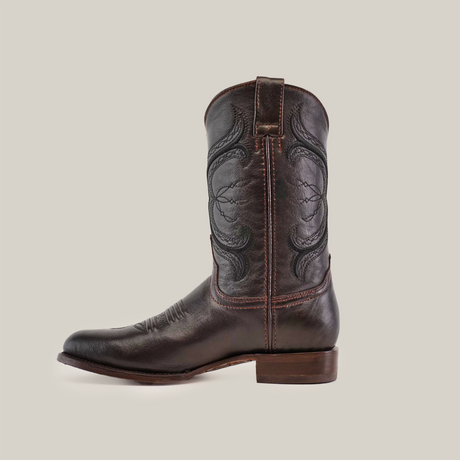 The Rush Brown - Roper Toe, a dark brown leather cowboy boot made from premium cowhide with decorative stitching, a roper toe, and a low heel, is positioned sideways on a plain white background.