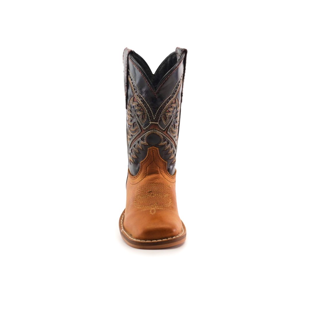 The Cater Honey Square Toe is a meticulous cowboy boot made from brown cowhide leather with a black embroidered shaft. It features intricate stitching and a rounded toe, set against a plain white background to emphasize its handcrafted quality.