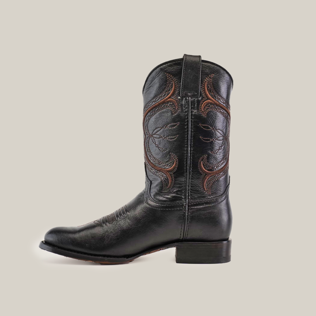 The Rush Black - Roper Toe boot, made from premium cowhide leather with detailed brown stitching on the shaft, captures Western spirit. Photographed from the side against a white background, it exudes timeless elegance and rugged authenticity