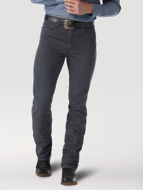 A person sports a blue denim shirt tucked into Wrangler Cowboy Cut Slim Fit jeans in charcoal gray, secured with a black belt. The ensemble is completed with black boots, and the photos focus spans from torso to feet against a plain background.