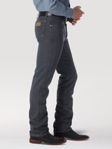 A person stands against a plain background wearing premium Wrangler Cowboy Cut Slim Fit Jean - 0936CHG in dark denim, paired with a blue shirt and black cowboy boots, captured from a shoulder-down side profile to highlight the fit and style.