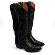 Pair of black cowboy boots with intricate designs and fringes on a white background