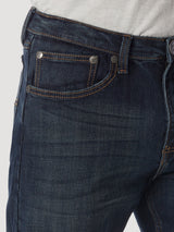 Close-up of a person wearing Wrangler 20X No. 33 Extreme Appleby Dark Wash Relaxed Straight Leg Jean, featuring visible stitching and metal rivets. The premium denim with a classic five-pocket design pairs perfectly with a light grey top.