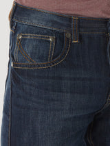 Close-up of a person wearing Wrangler® 20X® No. 42 - Vintage Boot Jean in dark blue denim with orange stitching and silver rivets, featuring front pocket detail, perfectly paired with a maroon top.