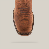 Close-up of the handcrafted Tan Brown Rough out - Waterproof - Composite Toe boot, made from premium cowhide leather. It features decorative stitching on the toe and a white stitched edge. The textured tan brown leather exudes rugged charm against a pristine white backdrop.