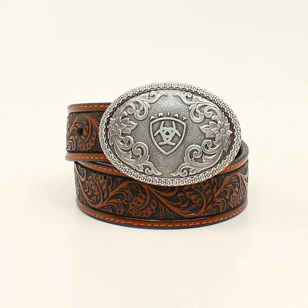 The Ariat Western Boys Belt Youth Leather Floral Embossed Tan - A1300208 features an intricate floral design and a large silver oval buckle with patterns and a central emblem. This coiled belt elegantly merges Western-inspired style with modern flair, part of our youth collection.