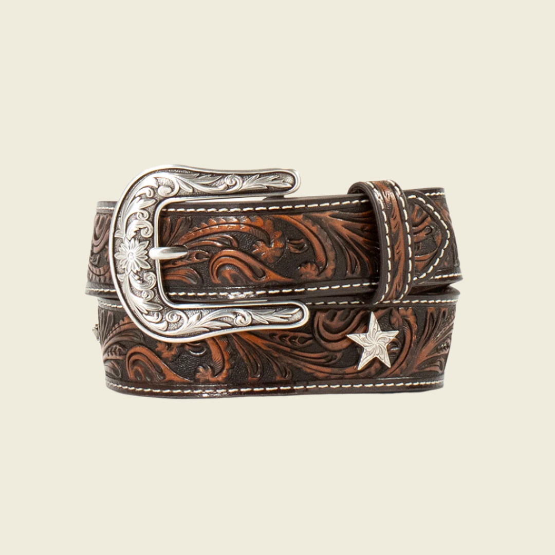 The Ariat Western Belt Leather Embossed Star Conchos Brown - A1308502 exemplifies authentic ranch style with its rolled brown leather and intricate floral engravings. It features a silver buckle with patterns, white edge stitching, and a silver star accent, making it a standout leather accessory.