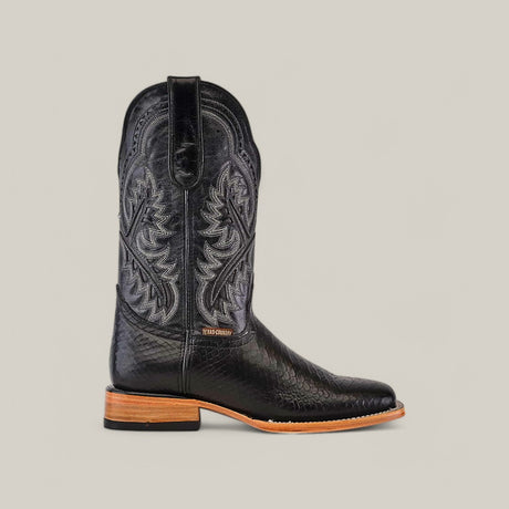 The Python Print Black - Square Toe is a single black cowboy boot with elaborate stitching, a low stacked wooden heel, and a light brown sole. It features pull tabs at the top, a slightly pointed toe with snakeskin print, set against a plain light gray background.