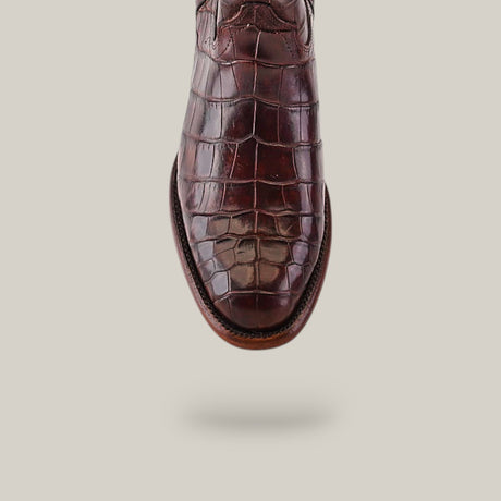 A close-up of the Exotic Full American Alligator - Brown - Round Toe shoe against a plain background highlights its intricate texture and craftsmanship reminiscent of luxury boots.